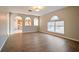 Open-concept living room featuring arched windows and doorways, wood floors, and views into the kitchen at 4191 Sw 110Th Ln, Ocala, FL 34476