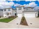 Attractive gray townhomes featuring attached garages and tidy landscaping on a sunny, bright day at 4653 Sparkling Shell Ave, Kissimmee, FL 34746