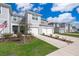 Well-kept gray townhomes with garages and manicured lawns under a beautiful, clear blue sky at 4653 Sparkling Shell Ave, Kissimmee, FL 34746