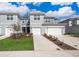 Charming, light gray townhomes with well-maintained lawns and attached garages under a bright blue sky at 4653 Sparkling Shell Ave, Kissimmee, FL 34746