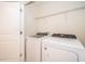 Bright laundry room with modern washer and dryer and overhead rack at 4653 Sparkling Shell Ave, Kissimmee, FL 34746