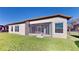 Exterior rear view of home featuring a screened lanai and manicured lawn at 472 Huntington Pines Dr, Ocoee, FL 34761