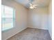 Neutral carpeted bedroom with ceiling fan and large window at 472 Huntington Pines Dr, Ocoee, FL 34761