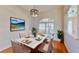 Elegant dining room with a marble table, seating for six, a modern chandelier, and ample natural light at 472 Huntington Pines Dr, Ocoee, FL 34761