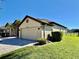 Charming one-story home features a large two-car garage and well-maintained landscaping on a sunny day at 472 Huntington Pines Dr, Ocoee, FL 34761