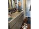 Small bathroom features a vanity with a gray cabinet and cluttered countertop at 491 Grandview Ave, Ormond Beach, FL 32176