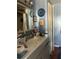 Bathroom with blue walls, white sink, and wall mirror at 491 Grandview Ave, Ormond Beach, FL 32176