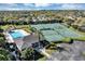 Aerial view showcasing tennis courts, basketball court, community pool, and clubhouse in a well-maintained community at 515 Mickleton Loop, Ocoee, FL 34761