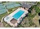 Aerial view displaying a community pool, tennis and basketball courts, and mature landscaping, enhancing the recreation opportunities at 515 Mickleton Loop, Ocoee, FL 34761