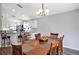 Open dining room with wood table and modern chandelier, flowing into the adjacent kitchen and breakfast bar at 515 Mickleton Loop, Ocoee, FL 34761