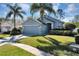 Charming single-story home with a well-manicured lawn and mature palm trees at 515 Mickleton Loop, Ocoee, FL 34761