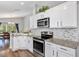 Modern kitchen showcasing white cabinets, granite countertops, stainless steel appliances and mosaic backsplash at 515 Mickleton Loop, Ocoee, FL 34761