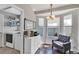 Cozy sitting area featuring bay windows, an armchair, and a decorative cabinet near the laundry room at 515 Mickleton Loop, Ocoee, FL 34761