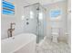 Elegant bathroom with tiled floors, glass shower, and tub at 5238 Baskin St, Orlando, FL 32814