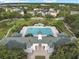 Aerial view showcases a community pool with ample seating, a green roofed clubhouse, and grassy areas at 5238 Baskin St, Orlando, FL 32814