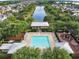 Aerial shot of a large community pool surrounded by lounge chairs, lush greenery, and a scenic lake at 5238 Baskin St, Orlando, FL 32814