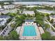 Elevated view of a community pool with lounge chairs, set among lush landscaping, and nearby lake at 5238 Baskin St, Orlando, FL 32814