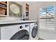 Bright laundry room with front load washer/dryer, shelving and shaker cabinets at 5238 Baskin St, Orlando, FL 32814