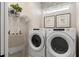 Bright laundry room with a modern washer and dryer, overhead storage shelf, and tasteful decor at 6312 Dew Drop Loop, St Cloud, FL 34771