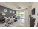 Modern living room with contemporary furnishings, a ceiling fan, and sliding glass doors leading to the backyard at 6312 Dew Drop Loop, St Cloud, FL 34771