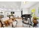 Elegant living room featuring classic furniture, piano, and dining area, filled with natural light at 724 Lake Davis Dr, Orlando, FL 32806