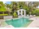 Stunning backyard features a sparkling pool, spa, pergola with hanging chairs, and manicured landscaping at 724 Lake Davis Dr, Orlando, FL 32806