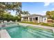 Gorgeous backyard pool and spa featuring lush landscaping and a modern, white home exterior at 724 Lake Davis Dr, Orlando, FL 32806