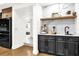 Modern wet bar with marble countertops, dark cabinetry, and open shelving in a neutrally decorated room at 724 Lake Davis Dr, Orlando, FL 32806