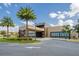 Community clubhouse featuring a modern design with palm trees and well-maintained landscaping at 7661 Recife Dr, Kissimmee, FL 34747