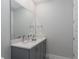 Bathroom with double vanity, quartz countertop, modern faucets, and large mirror at 7838 Spectrum Dr, Kissimmee, FL 34747