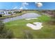 Scenic golf course view showcases lush green fairways, a tranquil pond, and sand traps for an exciting play at 7838 Spectrum Dr, Kissimmee, FL 34747