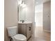 A modern bathroom vanity with gray wood cabinets and a sleek sink, alongside a toilet and bright lighting at 889 Megano Blvd, Deland, FL 32724