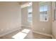 Bright hallway with neutral walls and wood-look flooring, illuminated by natural light from large windows at 889 Megano Blvd, Deland, FL 32724