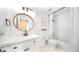 Modern bathroom with a sleek vanity, round mirror, and a shower-tub combo at 10236 Chorlton Cir, Orlando, FL 32832