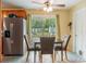 Dining area boasts stainless steel refrigerator, sliding glass door to back yard, and seating for four at 103 Brown Dr, Sanford, FL 32773