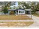 Inviting single-story home with a quaint front yard, covered carport, and mature trees providing shade at 103 Brown Dr, Sanford, FL 32773