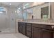 Modern bathroom featuring a walk-in glass shower, granite countertop, and a large mirror with vanity lighting at 10912 Mobberley Cir, Orlando, FL 32832