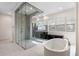 Bathroom featuring a soaking tub, a large glass shower, dark wood cabinets, and light tile floors at 10912 Mobberley Cir, Orlando, FL 32832