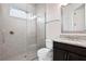 Bathroom featuring a shower with glass door, grey tile, toilet and vanity with a mirror at 10912 Mobberley Cir, Orlando, FL 32832