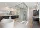Bright bathroom with a large glass shower, a soaking tub, dark wood cabinets, and neutral tile flooring at 10912 Mobberley Cir, Orlando, FL 32832