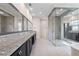 A bathroom featuring a granite countertop, dual mirrors, glass shower doors, and gray tiled floors at 10912 Mobberley Cir, Orlando, FL 32832