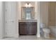 Bathroom featuring vanity with granite countertop, brown cabinets, and tiled floor at 10912 Mobberley Cir, Orlando, FL 32832