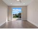 Unfurnished bedroom with hardwood floors, baseboard trim and balcony at 10912 Mobberley Cir, Orlando, FL 32832