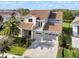 Two-story home featuring a large backyard, balcony, stone accents, and a three-car garage at 10912 Mobberley Cir, Orlando, FL 32832