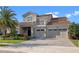 Elegant two-story home with stone accents, balcony, three-car garage, and lush landscaping at 10912 Mobberley Cir, Orlando, FL 32832