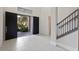 Bright foyer with tile flooring, staircase, and double front doors with exterior views at 10912 Mobberley Cir, Orlando, FL 32832