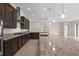 Stylish kitchen features a large island with granite countertop and stainless steel appliances at 10912 Mobberley Cir, Orlando, FL 32832