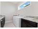 Bright laundry room with white washer and dryer, granite countertop, undermount sink, and window at 10912 Mobberley Cir, Orlando, FL 32832
