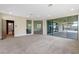 Spacious living room with plush carpet and sliding glass doors leading to the balcony, providing scenic views at 10912 Mobberley Cir, Orlando, FL 32832
