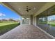 Wide angle, partially covered patio with brick pavers and views of the spacious backyard at 10912 Mobberley Cir, Orlando, FL 32832